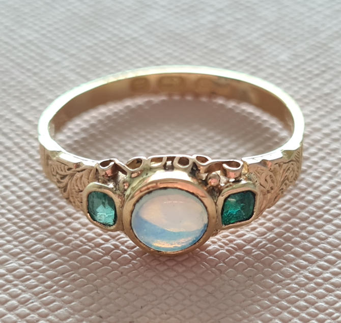 Gold ring set with opal and emeralds